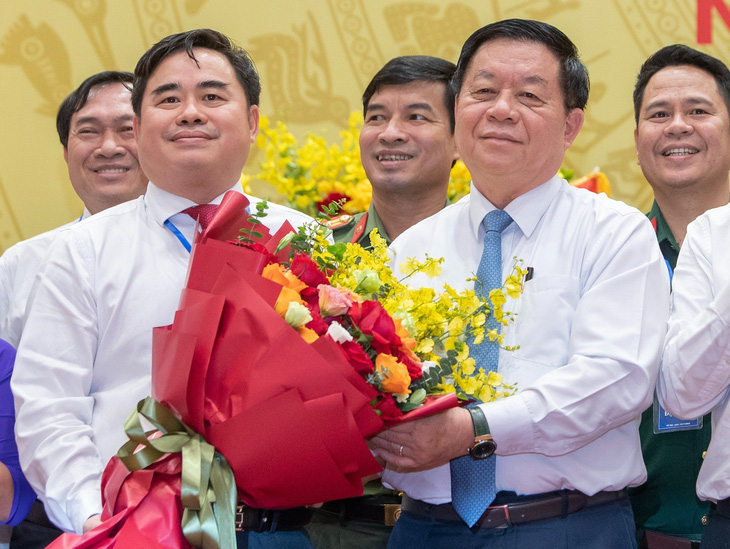 Trưởng Ban Tuyên giáo Trung ương Nguyễn Trọng Nghĩa (bên phải) trao hoa chúc mừng tân Chủ tịch Hội Xuất bản Việt Nam Phạm Minh Tuấn - Ảnh: BTC