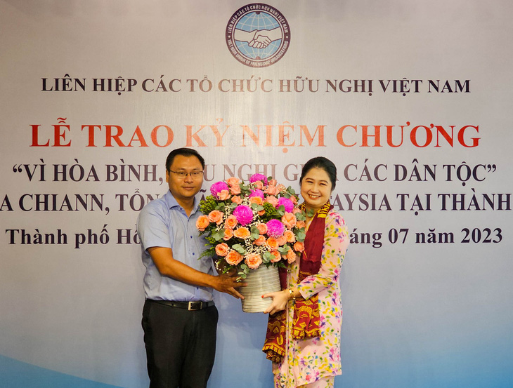 Ông Trương Minh Tước Nguyên - phó bí thư Thành Đoàn TP.HCM - trao hoa và quà cho bà Wong - Ảnh: NGỌC ĐỨC