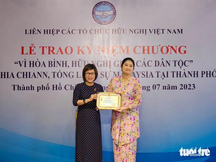 Bà Trần Hoàng Khánh Vân trao kỷ niệm chương Vì hòa bình và hữu nghị giữa các dân tộc cho Tổng lãnh sự Malaysia tại TP.HCM Wong Chia Chiann (phải) - Ảnh: NGỌC ĐỨC