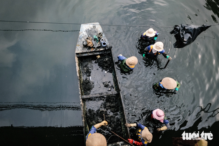 Công nhân vớt rác thải trên sông Tô Lịch - Ảnh: NAM TRẦN