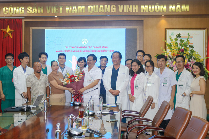 Giám đốc Bệnh viện Bạch Mai Đào Xuân Cơ tặng hoa chúc mừng bệnh nhân H.B. - Ảnh: BẠCH MAI