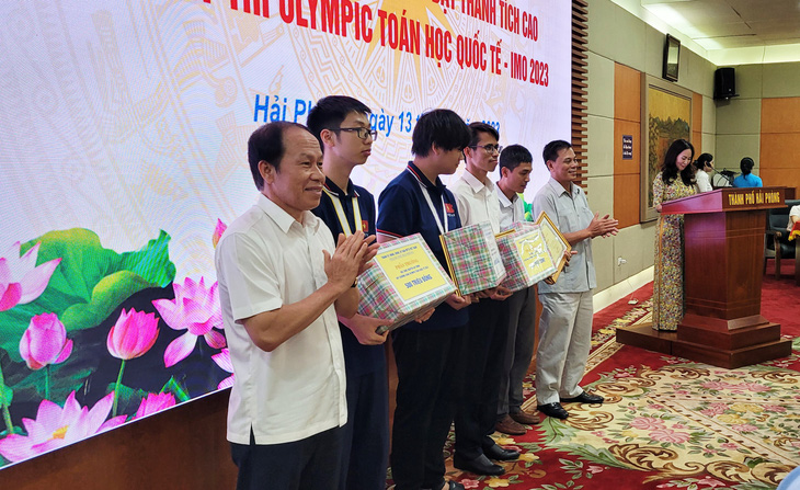 Lãnh đạo UBND thành phố Hải Phòng trao thưởng, biểu dương các nam sinh và thầy giáo hướng dẫn để giành huy chương vàng toán quốc tế - Ảnh: TIẾN THẮNG