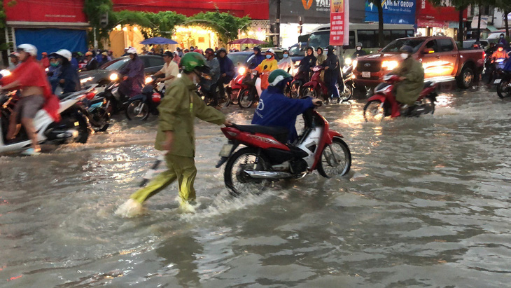 Sau cơn mưa lớn cuối tháng 6, người dân phải đối mặt với tình trạng ngập nước trên đường Đồng Khởi, TP Biên Hòa - Ảnh: A LỘC