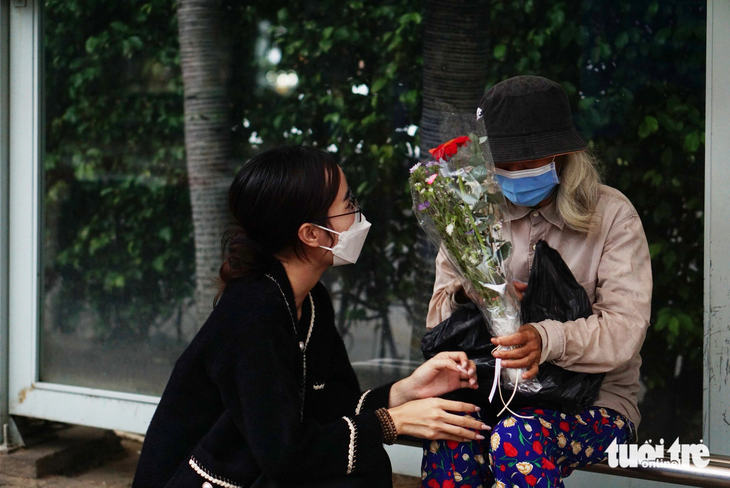 Chị Khánh Ngọc tự tay tặng hoa cho một cụ bà vô gia cư