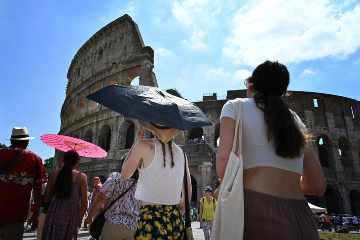 Du khách đi tham quan dưới nắng nóng ở Rome ngày 14-7 - Ảnh: AFP