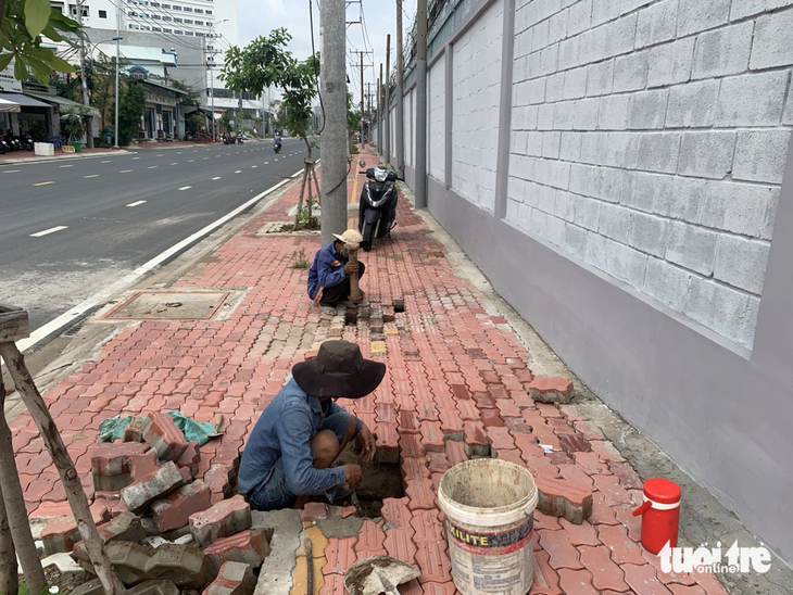 Chiều 15-7, các công nhân sửa chữa vỉa hè bị xói lở - Ảnh: Ban quản lý dự án đầu tư xây dựng khu vực TP Thủ Đức