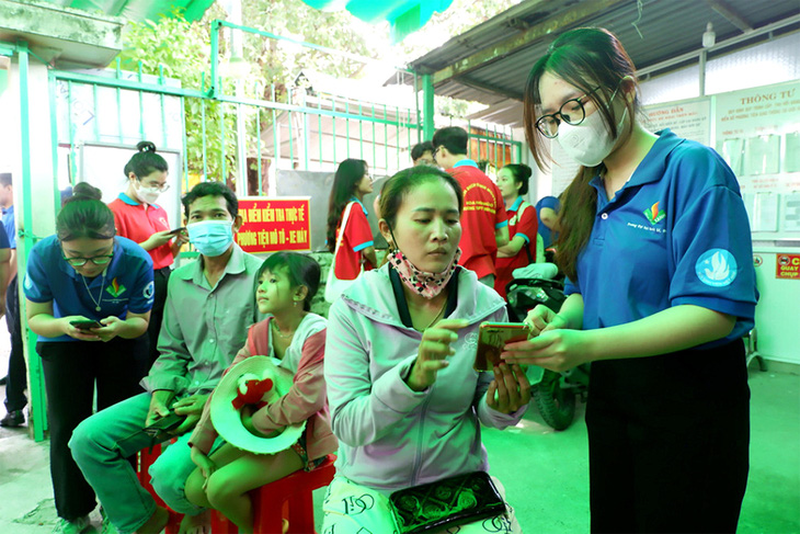 Chiến sĩ tình nguyện hướng dẫn người dân thủ tục hành chính ở bộ phận một cửa tại UBND huyện Bình Chánh - Ảnh: K.ANH