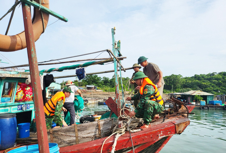 Cán bộ, chiến sĩ Đồn biên phòng cửa khẩu cảng Vạn Gia thuộc biên phòng tỉnh Quảng Ninh giúp dân gia cố tàu thuyền, lồng bè nuôi thủy sản ứng phó bão số 1 - Ảnh: NGUYỄN CHIẾN