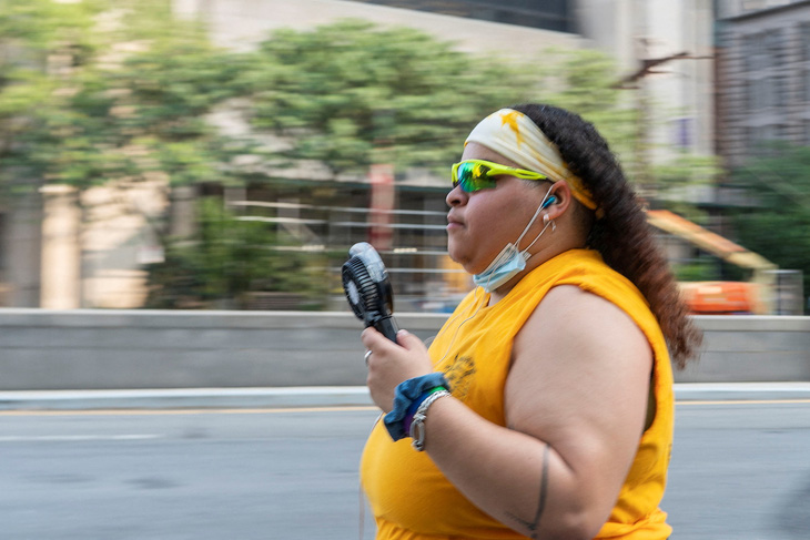 Một cư dân thành phố New York, Mỹ, xài quạt cầm tay xua đi cái nóng - Ảnh: REUTERS