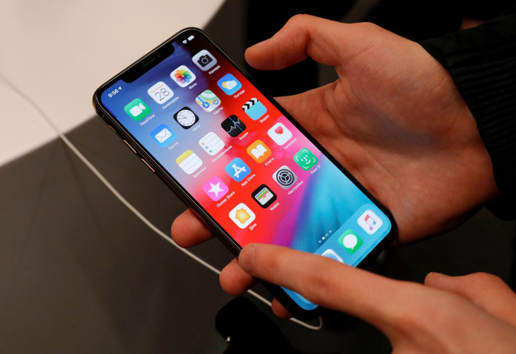 Một khách hàng dùng thử điện thoại iPhone tại cửa hàng Apple ở Matxcơva, Nga vào tháng 9-2018 - Ảnh: REUTERS