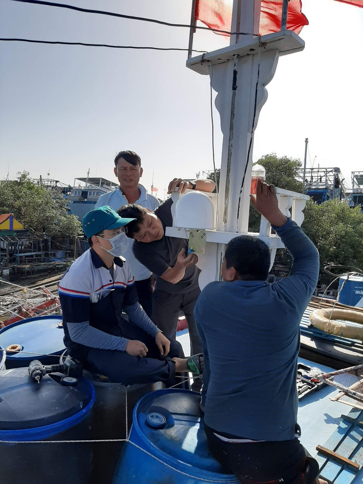 Nhân viên Công ty Hiệp lực phát triển Việt lắp đặt thiết bị giám sát hành trình kiêm điện thoại vệ tinh cho các tàu cá tại Vũng Tàu - Ảnh: NGỌC MINH