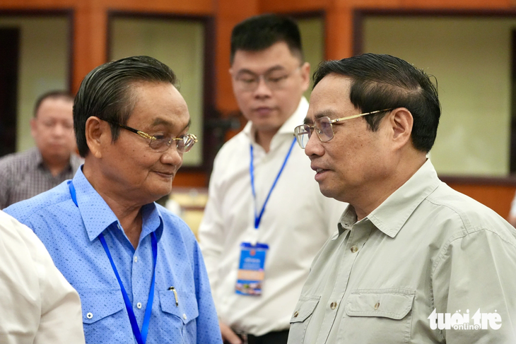 TS Trần Du Lịch (bìa trái) trao đổi với Thủ tướng Phạm Minh Chính tại hội nghị - Ảnh: HỮU HẠNH