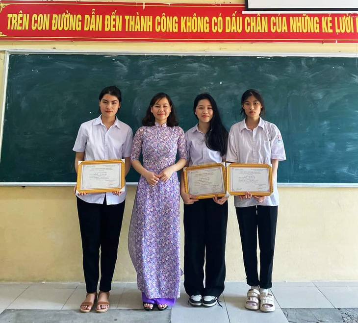 Trần Ngọc Đan Thanh (thứ hai, từ phải sang) chụp hình cùng cô giáo chủ nhiệm và bạn học đạt thành tích trong kỳ thi ngữ văn cấp tỉnh - Ảnh: Giáo viên cung cấp