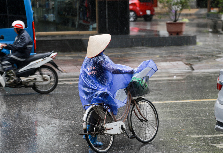 Người dân Móng Cái (Quảng Ninh) di chuyển trong mưa bão số 1 sáng 18-7 - Ảnh: C.TUỆ