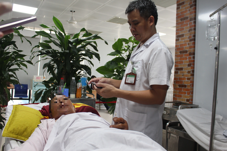 Bác sĩ Nguyễn Trung Nguyên thăm khám cho bệnh nhân bị rắn cắn - Ảnh: DƯƠNG LIỄU