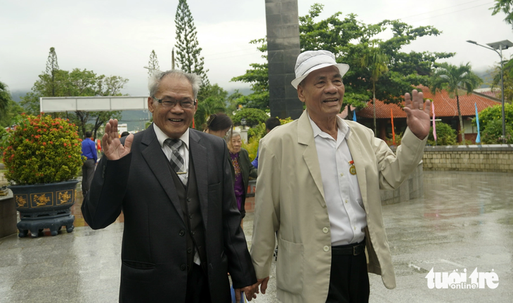 Cựu tù chính trị Trần Đức Dục (trái) và đồng đội nắm tay nhau đi viếng những đồng đội đã nằm xuống ở Nghĩa trang Hàng Dương - Ảnh: ĐÔNG HÀ 