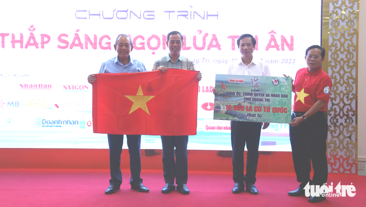 Nguyên Phó thủ tướng thường trực Trương Hòa Bình trao tặng cờ Tổ quốc cho lãnh đạo tỉnh Quảng Trị - Ảnh: QUỐC NAM