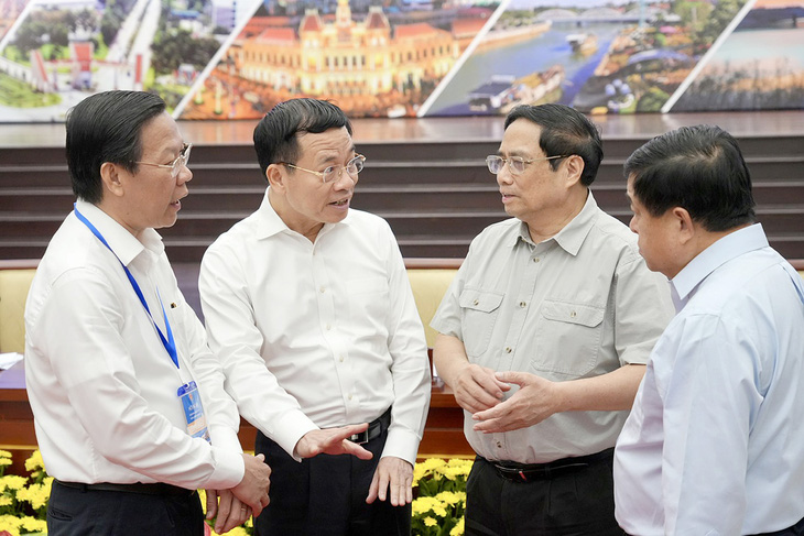 Thủ tướng Phạm Minh Chính trao đổi bên lề cùng các đại biểu tại hội nghị  - Ảnh: HỮU HẠNH