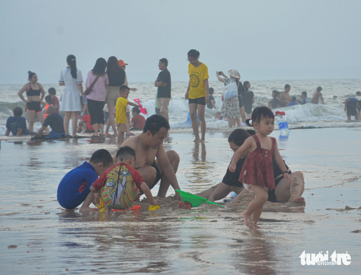 Du khách vui chơi, tắm biển ở Phan Thiết - Ảnh: ĐỨC TRONG