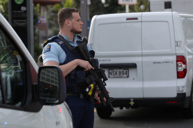 Một sĩ quan cảnh sát đứng gác sau vụ xả súng ở Auckland, New Zealand vào ngày 20-7 - Ảnh: REUTERS
