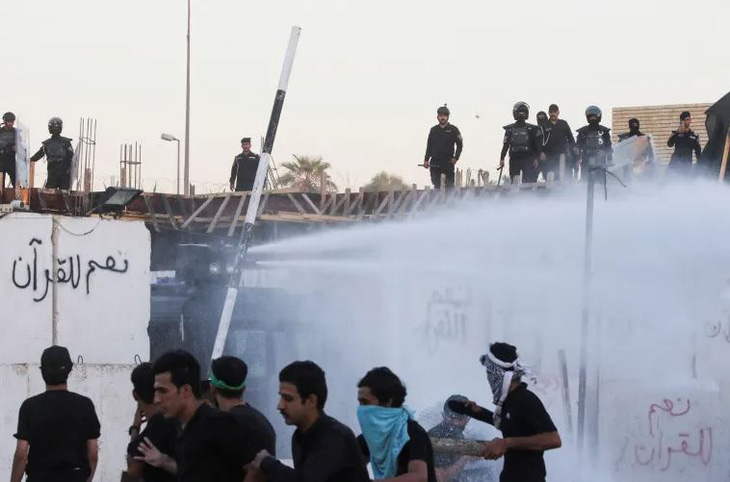 Lực lượng an ninh triển khai vòi rồng khi người biểu tình tụ tập gần Đại sứ quán Thụy Điển ở Baghdad, Iraq sau vụ đột nhập sáng 20-7 - Ảnh: REUTERS