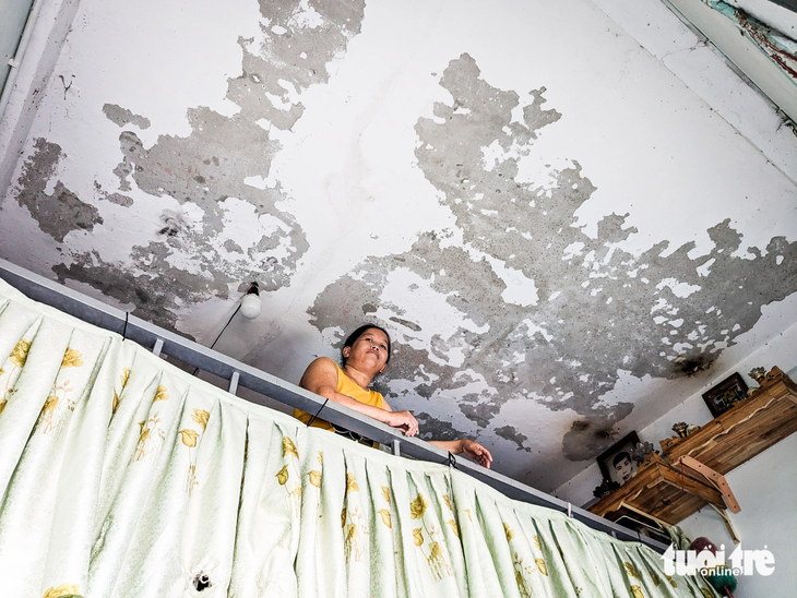 Bà Lê Thị Loan trong căn hộ K311 đã bị bong tróc xi măng trần nhà - Ảnh: TẤN LỰC