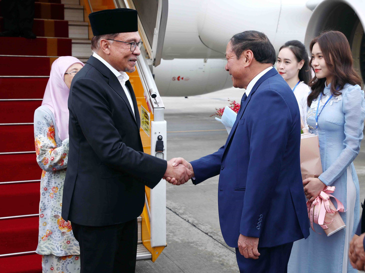 Thủ tướng Malaysia Anwar Ibrahim bắt tay các quan chức Việt Nam đón đoàn tại sân bay Nội Bài (Hà Nội) - Ảnh: TTXVN