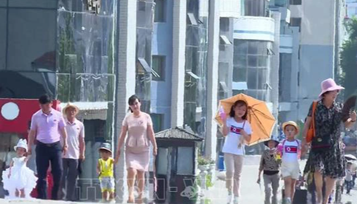 Người dân đi trên một con đường ở Triều Tiên dưới nắng nóng gay gắt ngày 20-7-2023 - Ảnh: YONHAP/TTXVN