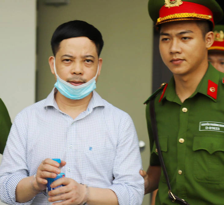 Phạm Trung Kiên (trái) Cựu thư ký thứ trưởng Bộ Y tế được dẫn giải đến phiên tòa xét xử vụ chuyến bay giải cứu - Ảnh: DANH TRỌNG