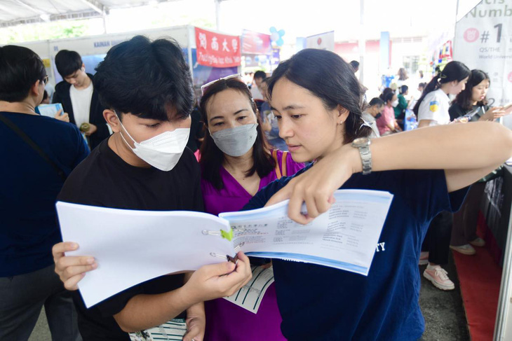 Chị Thu Hương và em Mạnh Hùng tìm hiểu thông tin tại Trường ĐH Quốc tế Dong Hwa - Ảnh: QUANG ĐỊNH