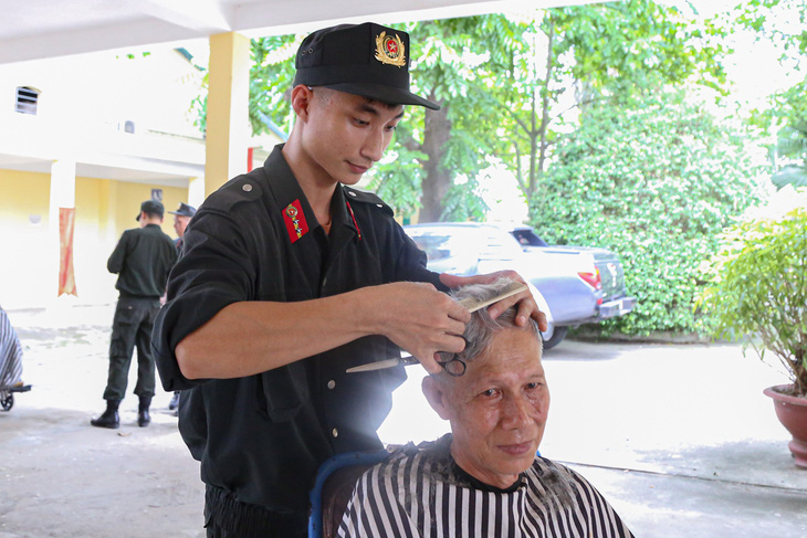 Chiến sĩ Quách Quang Trường từng theo học cắt tóc trước khi gia nhập lực lượng cảnh sát cơ động nên thành thạo trong tạo kiểu, hớt tóc - Ảnh: HÀ QUÂN