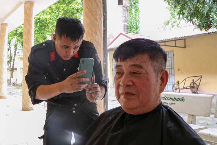 &quot;Thợ cắt tóc&quot; không quên chụp lại tác phẩm cho các bác thương binh ngắm - Ảnh: HÀ QUÂN