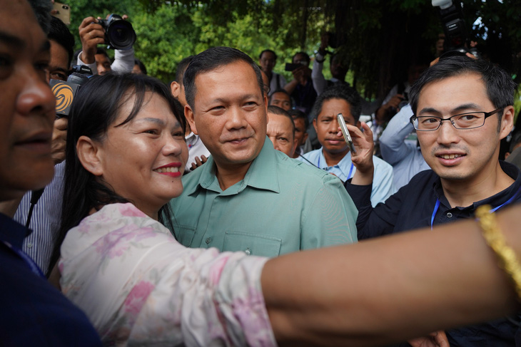 Ông Hun Manet chụp ảnh cùng người dân Phnom Penh sau khi bỏ phiếu. Trước ngày bầu cử, ông Hun Sen từng tuyên bố trên truyền hình: "Trong 3 hoặc 4 tuần nữa, Hun Manet có thể trở thành thủ tướng. Điều đó phụ thuộc vào việc Hun Manet có làm được hay không" - Ảnh: AFP
