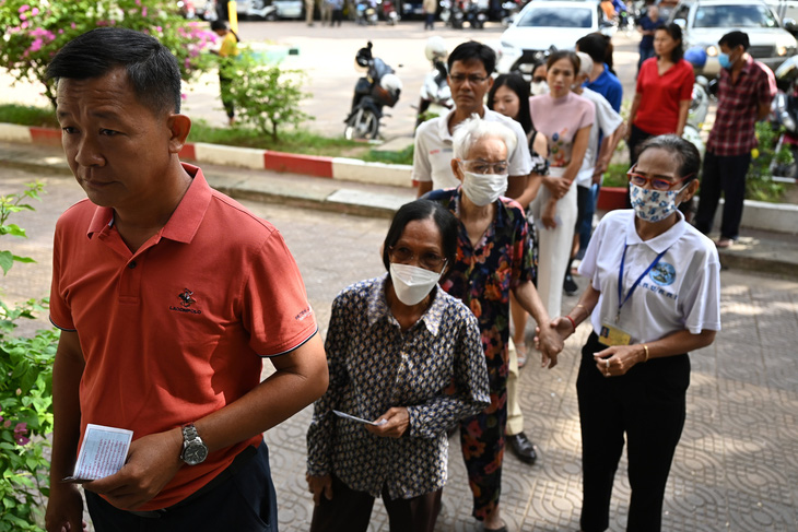 Người dân xếp hàng chờ bỏ phiếu tại một điểm bỏ phiếu ở thủ đô Phnom Penh. Tổng cộng 23.789 điểm bỏ phiếu đã được thiết lập trên cả nước - Ảnh: AFP