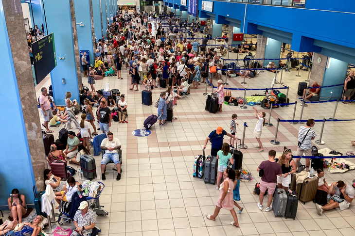 Khách du lịch đợi ở sảnh khởi hành của sân bay khi các hoạt động sơ tán diễn ra do cháy rừng trên đảo Rhodes của Hy Lạp vào ngày 23-7 - Ảnh: AFP