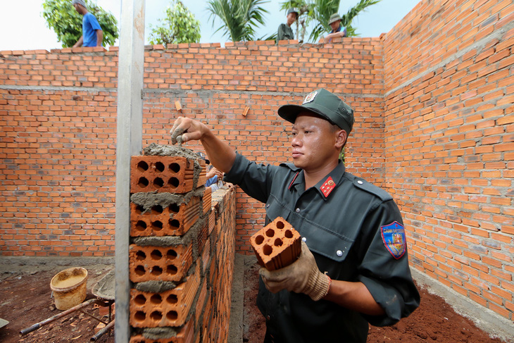 Chiến sĩ cảnh sát cơ động xây nhà giúp người dân - Ảnh: NGUYỄN HẰNG