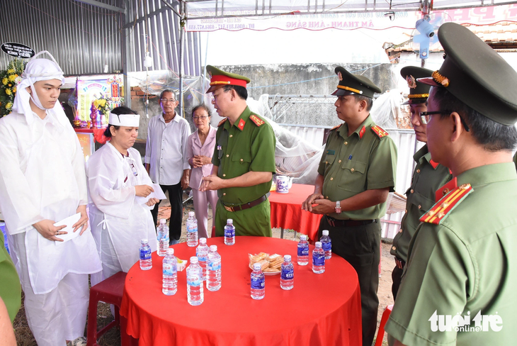 Đại tá Nguyễn Văn Lộc - phó giám đốc Công an tỉnh Tiền Giang - thăm hỏi, động viên chia buồn với vợ con ông Duy - Ảnh: H.T.
