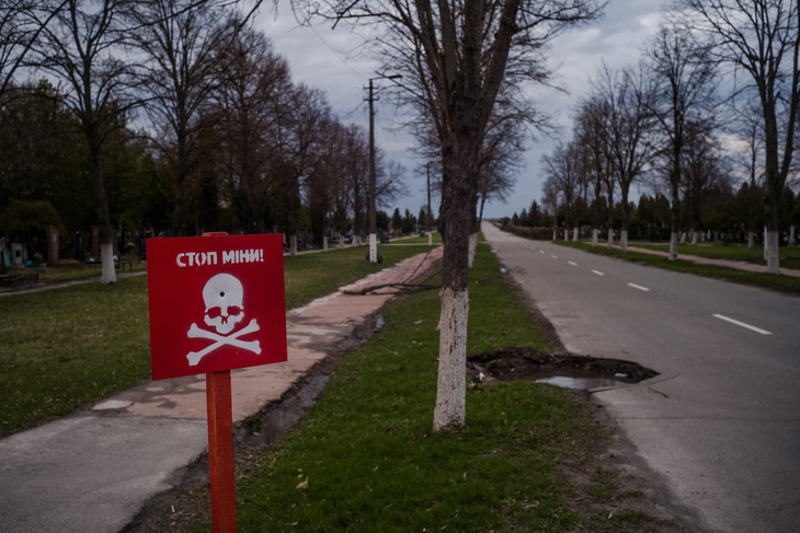 Biển cảnh báo mìn tại một nghĩa trang ở thành phố Chernihiv, Ukraine, tháng 4-2022 - Ảnh: WASHINGTON POST