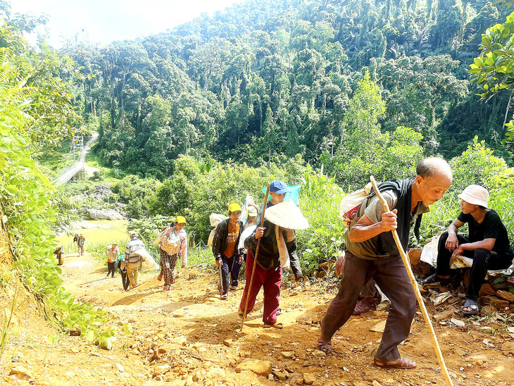Người làng Tu Nương cùng hợp sức chuyển vật liệu lên đắp đường - Ảnh: B.D.