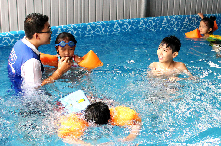 Sinh viên tình nguyện dạy bơi miễn phí cho trẻ tại TP.HCM mỗi dịp hè - Ảnh: Q.L.