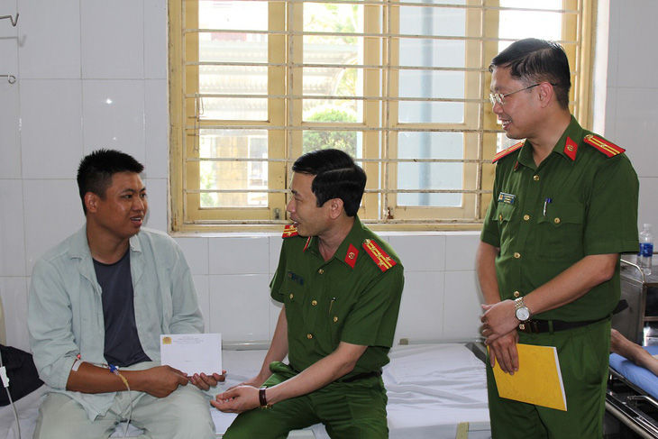 Lãnh đạo Công an tỉnh Hà Nam thăm hỏi thượng sĩ Nguyễn Văn Sỹ bị thương trong quá trình tham gia chữa cháy, cứu nạn đưa các nạn nhân ra ngoài - Ảnh: LAN ANH