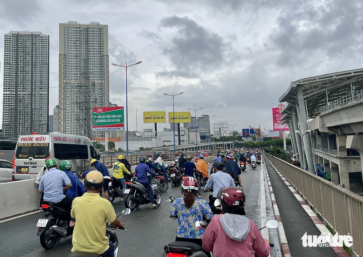 Ít nhất 15 chiếc xe máy bị té trên cầu Sài Gòn vào chiều 25-7 - Ảnh: CHÂU TUẤN