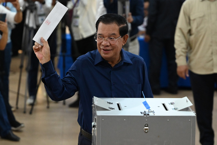 Thủ tướng Campuchia Hun Sen giơ phiếu bầu cử của ông tại điểm bỏ phiếu ở tỉnh Kandal ngày 23-7 - Ảnh: AFP
