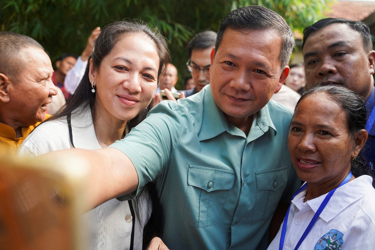 Ông Hun Manet, con trai Thủ tướng Campuchia Hun Sen, chụp ảnh cùng cử tri sau khi đi bỏ phiếu ngày 23-7 - Ảnh: REUTERS