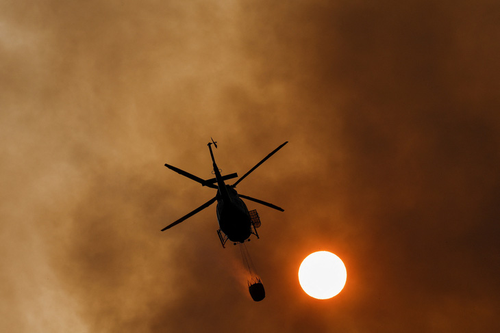 Trực thăng mang nước dập tắt đám cháy rừng ở khu vực Pico de las Nieves, thuộc đảo Canary của Tây Ban Nha ngày 25-7 - Ảnh: REUTERS