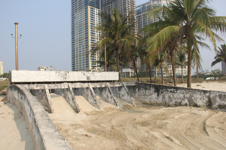 Một cống nước mưa ở Đà Nẵng được lấp cát để đảm bảo mỹ quan. Tuy nhiên khi mưa lớn nước mưa thoát từ đây ra rất mạnh - Ảnh: TRƯỜNG TRUNG