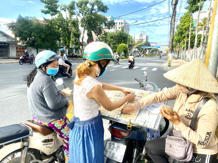 Tại ngã ba đường Trần Hưng Đạo - Trần Văn Sắc (phường 2, TP Sóc Trăng, tỉnh Sóc Trăng), chị Linh đậu xe gắn máy, bày vé số dưới lòng đường, rất nguy hiểm cho những người tham gia giao thông