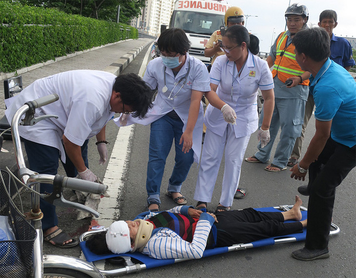 Nhân viên cấp cứu ngoại viện sơ cứu cho nạn nhân bị tai nạn giao thông ở Q.1, TP.HCM - Ảnh: T.T.D.