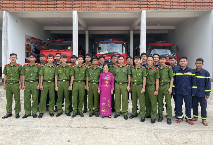 Bà Trần Thị Chinh chụp ảnh lưu niệm cùng đồng đội của con - Ảnh: Công an cung cấp