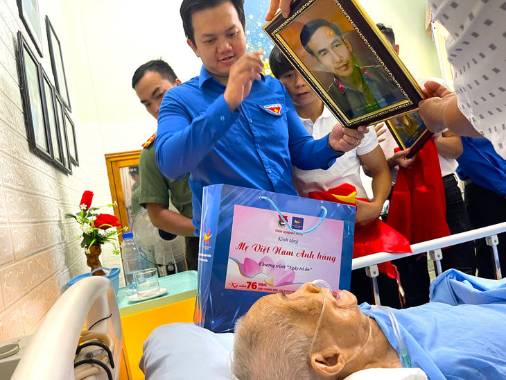 Mẹ Việt Nam anh hùng Nguyễn Thị Phú gắng gượng xem di ảnh đã được phục dựng của liệt sĩ Lê Huân - Ảnh: THỤC NGHI